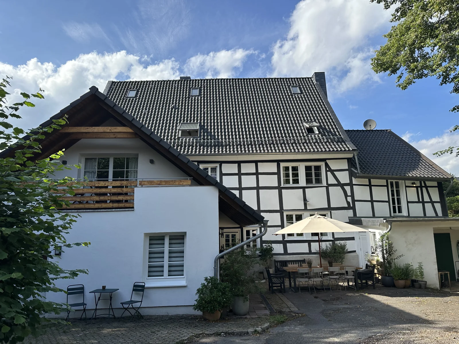 Gesamtansicht des Fachwerkhauses auf Gut Bechhausen mit Terrasse und Garten