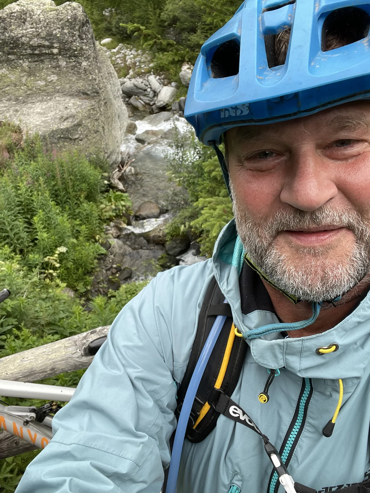 Robert Gerhards mit Mountainbike-Helm und Fahrrad an einem Gebirgsbach